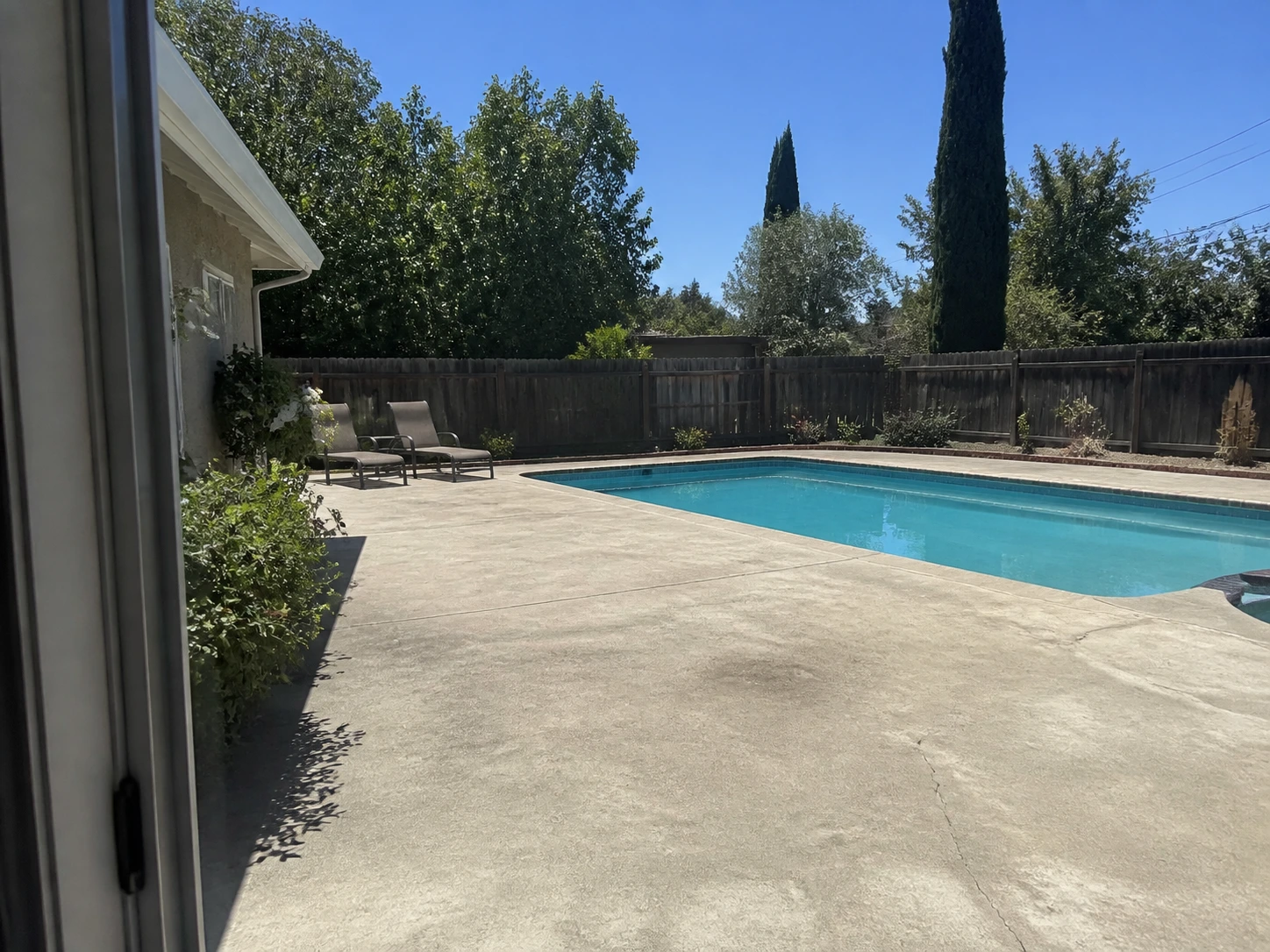 Normale foto scattata con smartphone di una vecchia area piscina con pavimentazione usurata